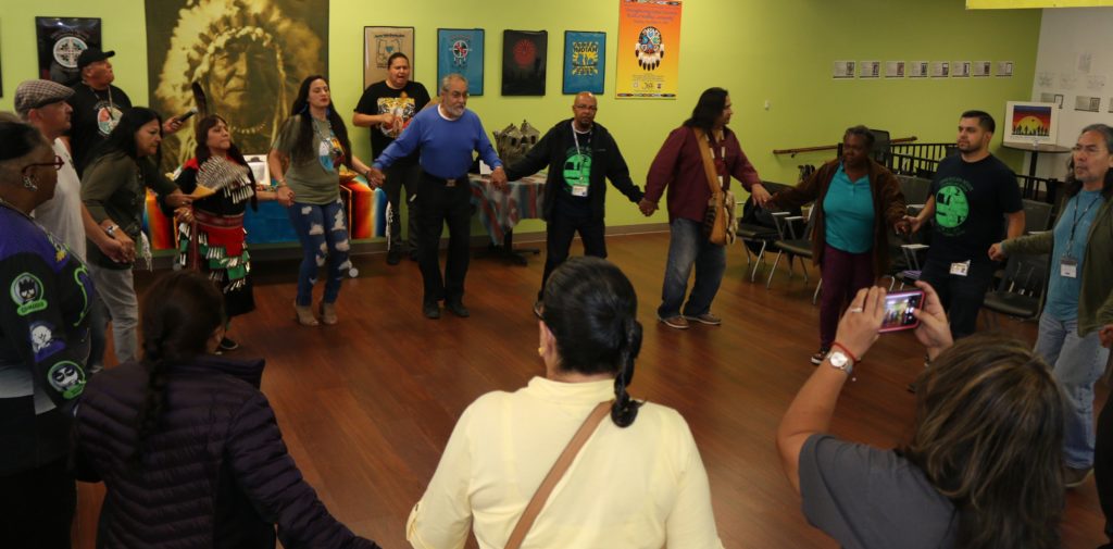 People dancing in a circle at LACDMH's Peer Resource Center