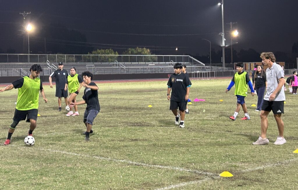 Students practicing soccer with LAFC player Kenny Nielsen